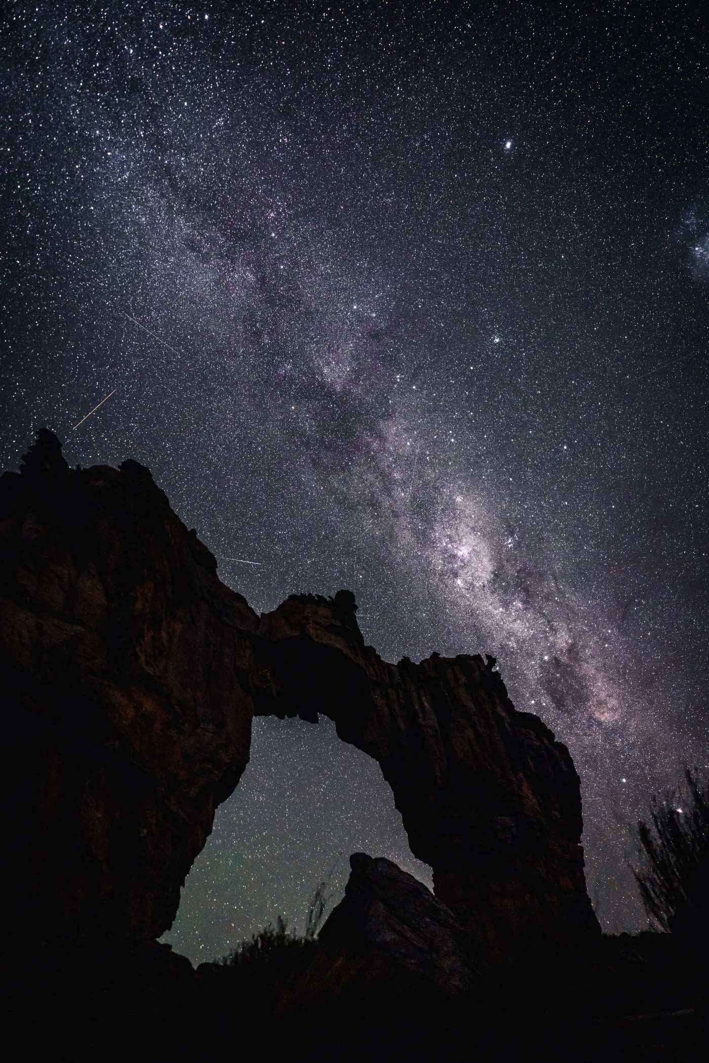Night sky over a natural stone arch